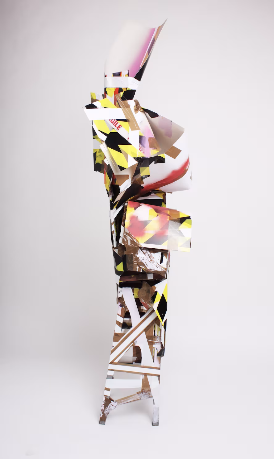 Escaping the Confines (2020), reclaimed plastic, reclaimed stool, packaging tape, cardboard, spray paint and paint, 190 x 30 x 30 cm.